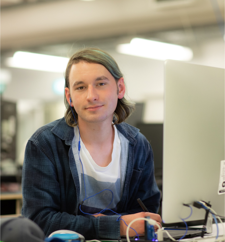 A young guy in front of a computer working